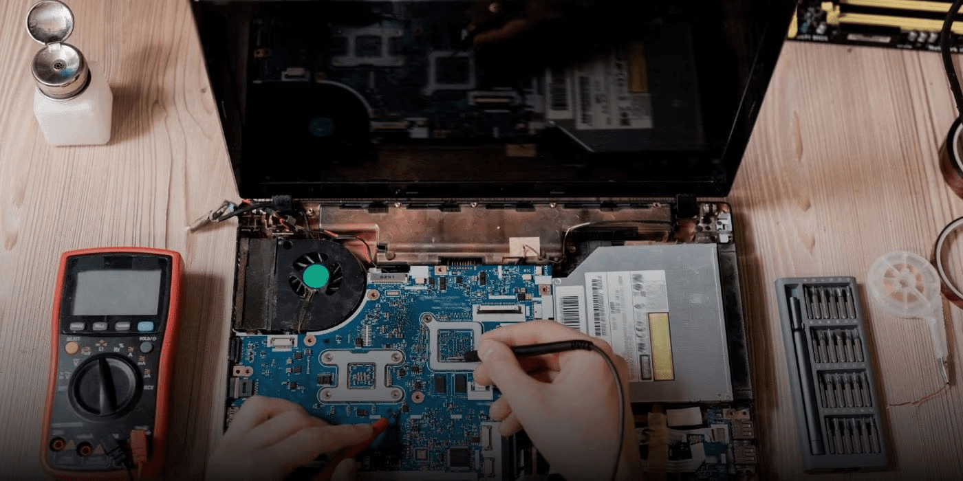 Persona reparando laptop averiada con pantalla negra