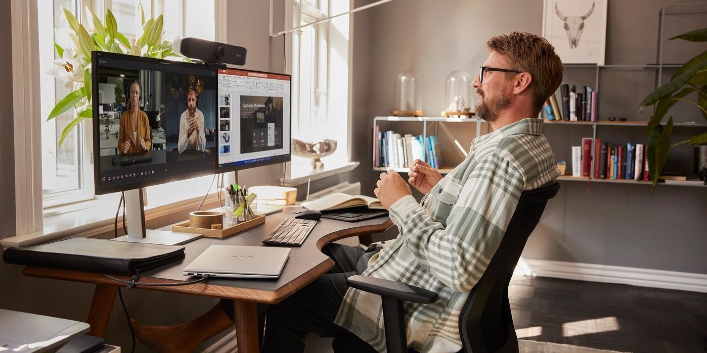Hombre profesional en videollamada con monitor HP y c&aacute;mara HP Poly en oficina en casa- trabajo remoto empresarial