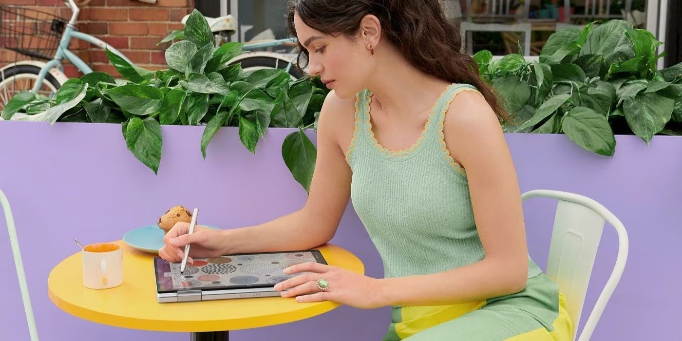Mujer trabajando de forma reomta en diseño gráfico, usando una laptop convertible HP.